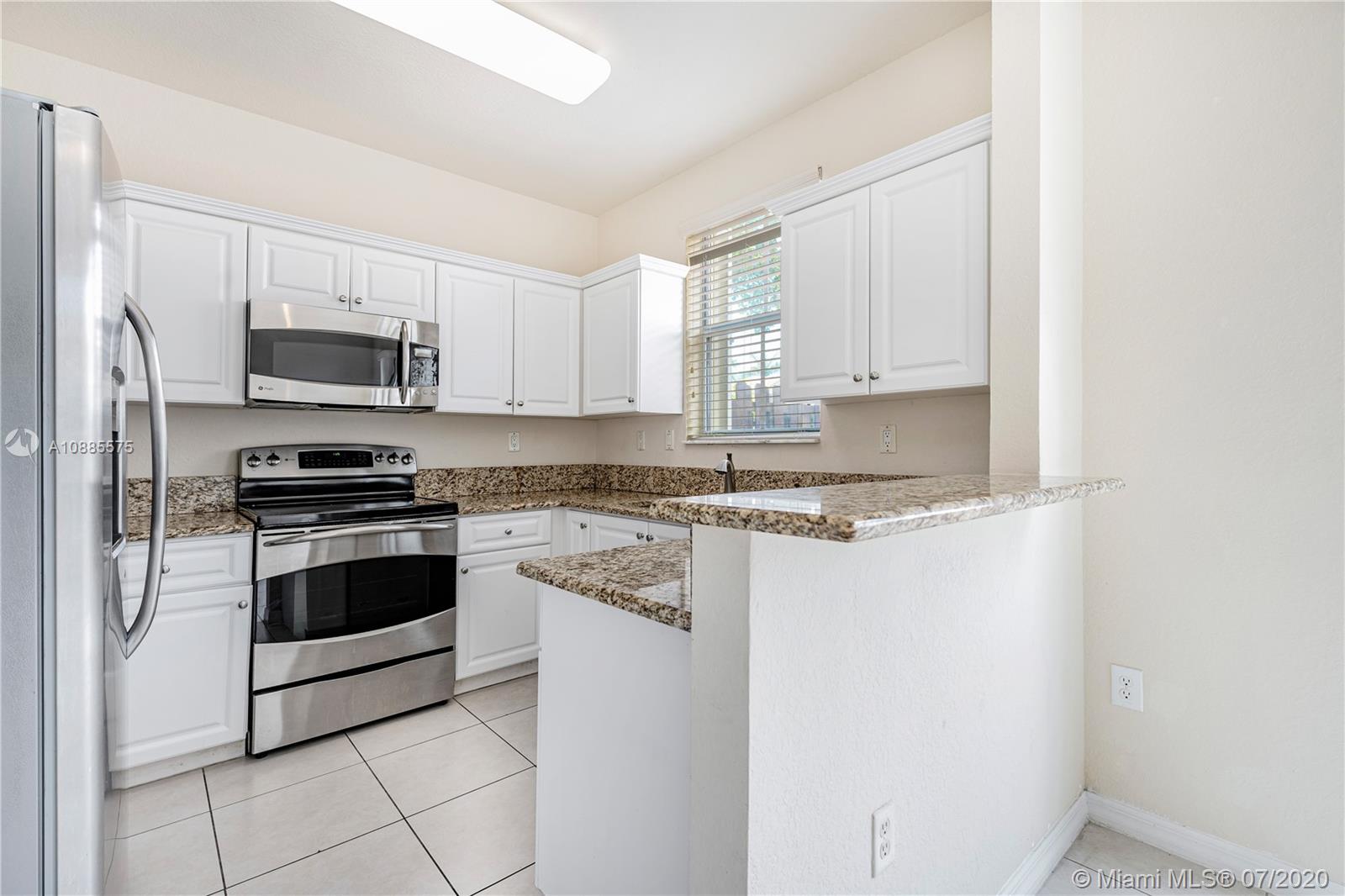 11926 Southwest 152nd Place Miami, FL 33196 - Photo 15 of 48 a kitchen with granite countertop white cabinets and stainless steel appliances