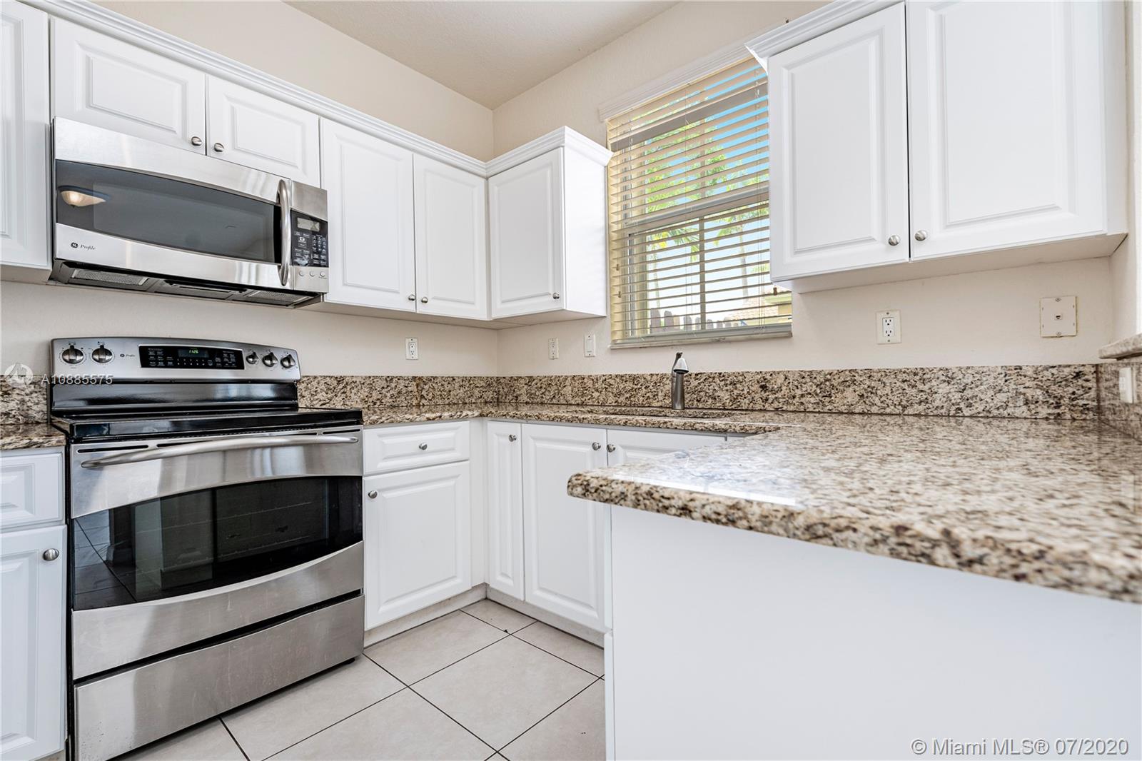 11926 Southwest 152nd Place Miami, FL 33196 - Photo 16 of 48 a kitchen with stainless steel appliances granite countertop white cabinets granite counter tops and a window
