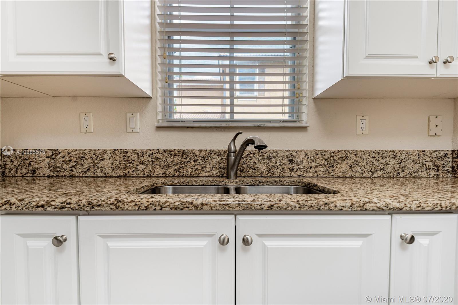 11926 Southwest 152nd Place Miami, FL 33196 - Photo 17 of 48 a kitchen with a granite countertop white cabinets and a window
