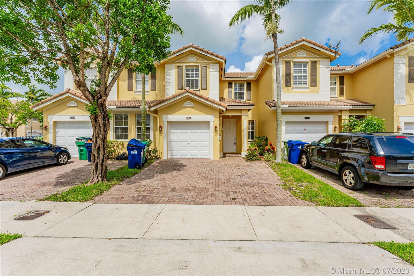 11926 Southwest 152nd Place Miami, FL 33196 - Photo 3 of 48 a front view of a house with a yard and garage