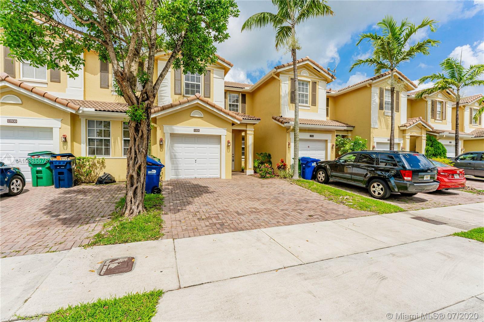 11926 Southwest 152nd Place Miami, FL 33196 - Photo 6 of 48 a front view of a house with a yard and garage