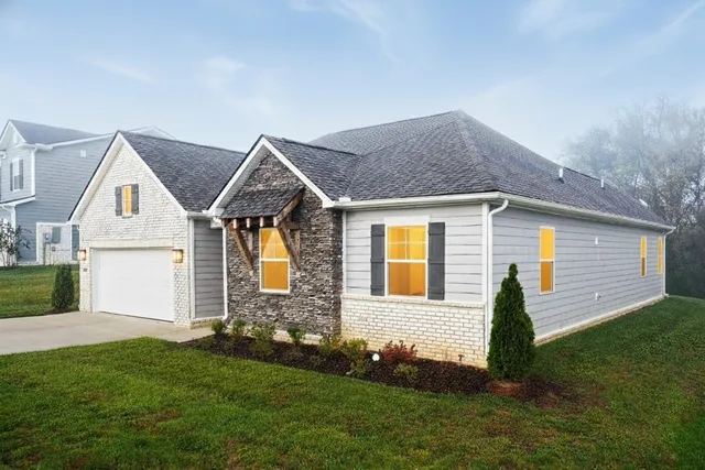 a front view of a house with a garden and yard