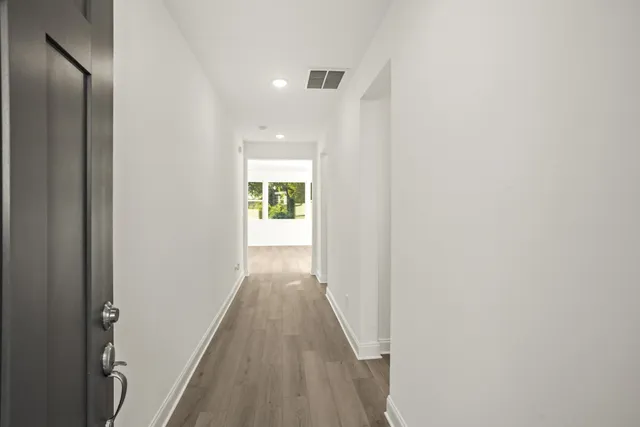 a view of a hallway with wooden floor