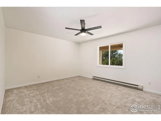 a view of a big room with wooden floor and windows