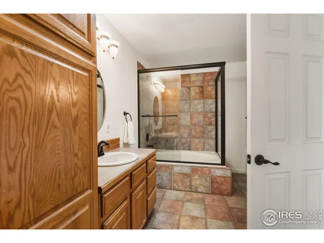 a bathroom with a tub sink mirror and a shower