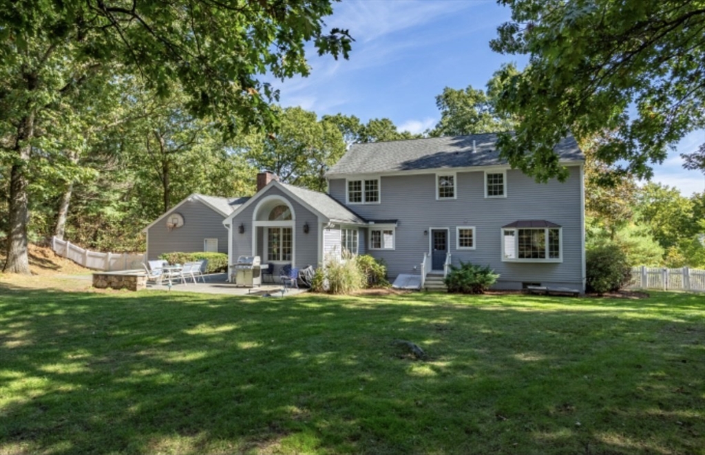 a front view of a house with a yard and trees