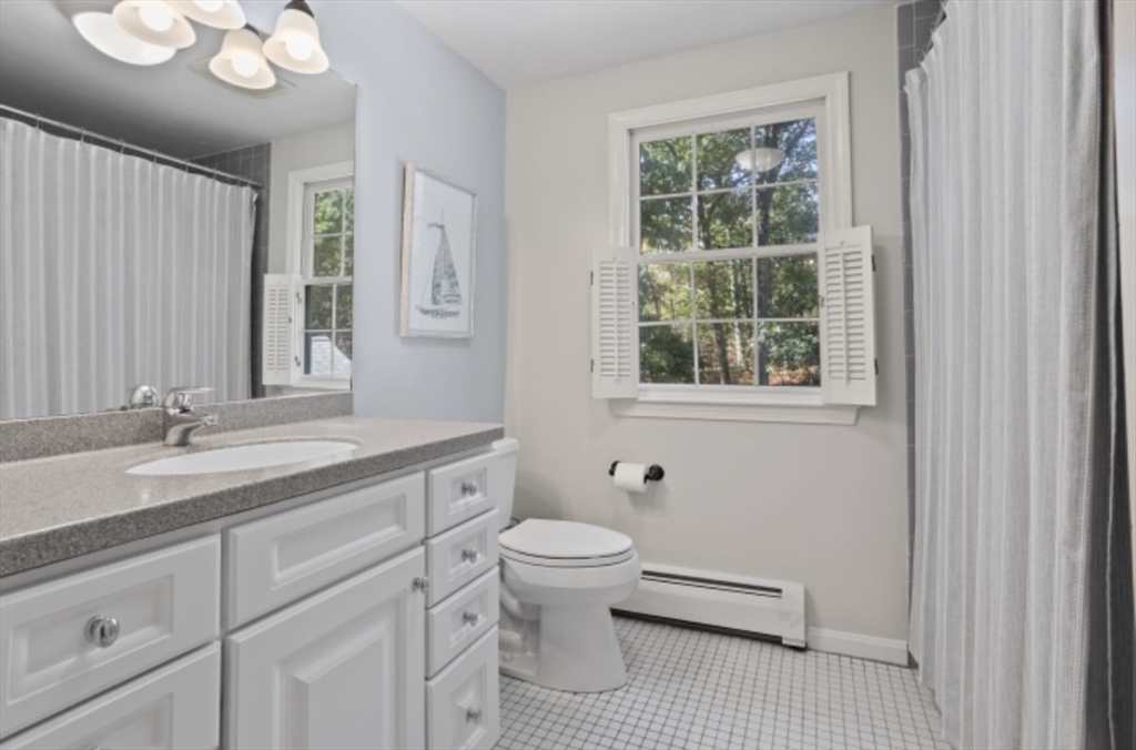 4 Kitson Park Drive Lexington, MA 02421 - Photo 22 of 38 a bathroom with a granite countertop toilet a sink a mirror and a window