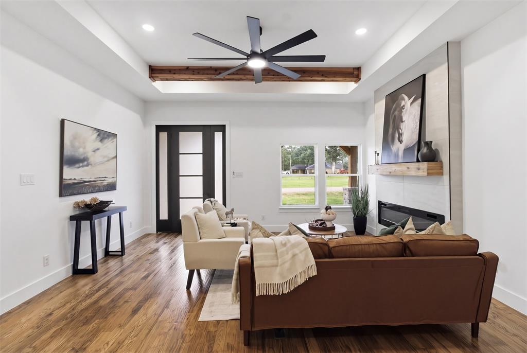 429 Waterboard Road Trinidad, TX 75163 - Photo 7 of 25 Living space featuring wood-finish flooring, a modern linear fireplace with a light-toned tile surround, and a natural wood mantel