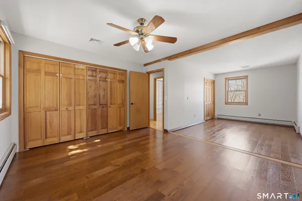 a view of a livingroom with a chandelier fan and windows