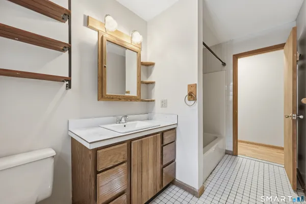 a bathroom with a sink a toilet a mirror and shower