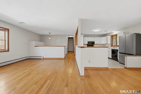 a view of a kitchen with a sink stove cabinets and empty room