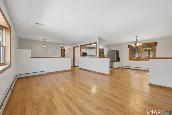 a view of a big room with wooden floor and windows