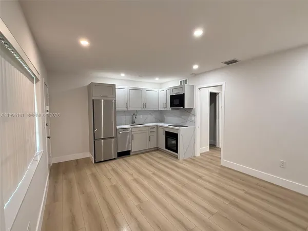 a large kitchen with a white stove top oven and refrigerator