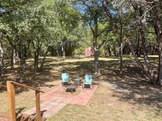 a backyard of a house with table and chairs