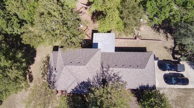 an aerial view of a house with yard and trees