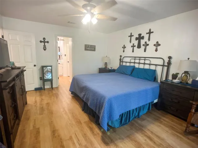 a bedroom with a bed and a flat tv screen on dresser