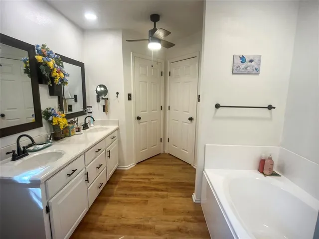 a bathroom with a tub sink and mirror