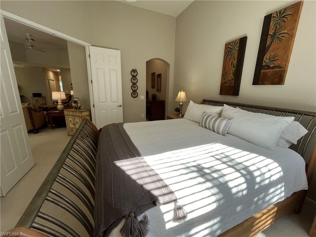 6809 Ascot Drive, Unit 202 Naples, FL 34113 - Photo 11 of 38 a bedroom with a bed and a mirror