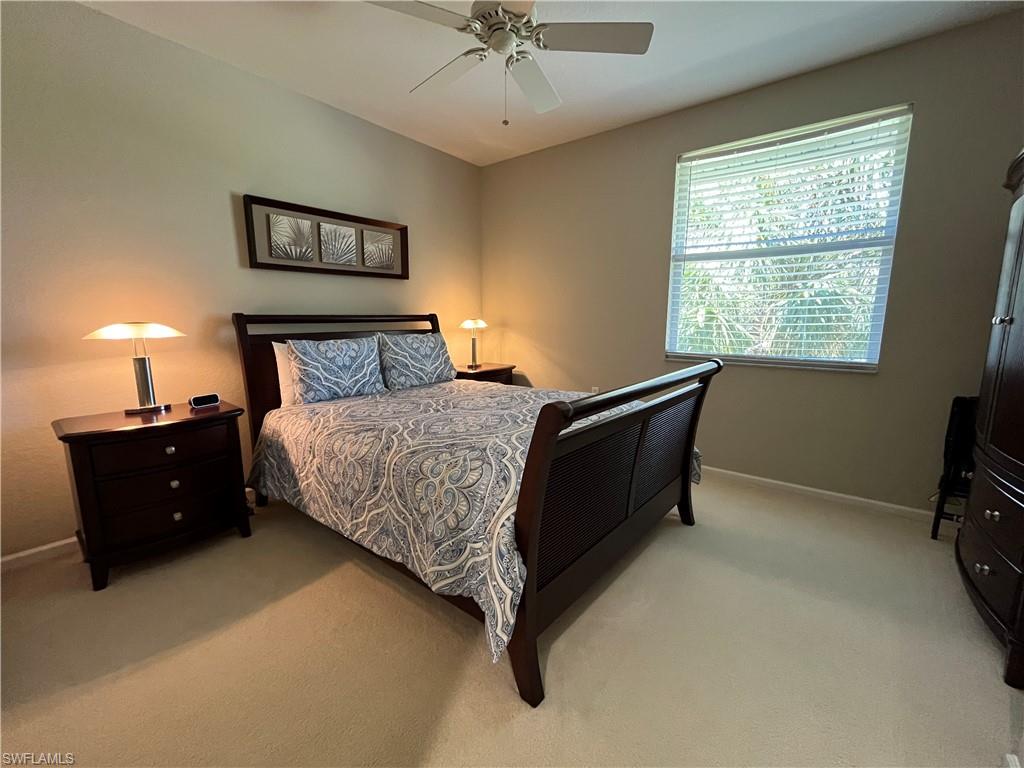 6809 Ascot Drive, Unit 202 Naples, FL 34113 - Photo 14 of 38 a bedroom with a bed and a ceiling fan