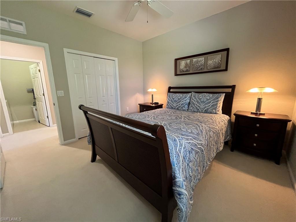 6809 Ascot Drive, Unit 202 Naples, FL 34113 - Photo 15 of 38 a bedroom with a bed and a lamp on dresser