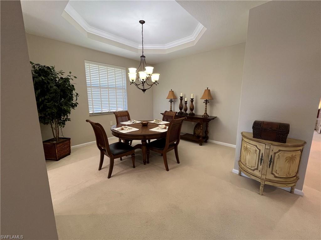 6809 Ascot Drive, Unit 202 Naples, FL 34113 - Photo 5 of 38 a view of a dining room with furniture and chandelier