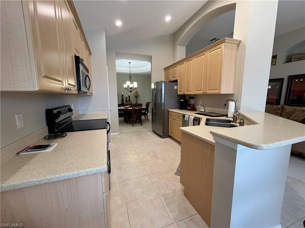 6809 Ascot Drive, Unit 202 Naples, FL 34113 - Photo 7 of 38 a kitchen with a sink a stove and a refrigerator