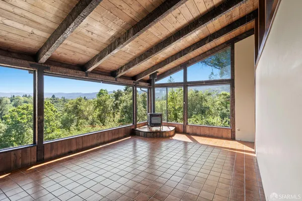 a view of an empty room with wooden floor and a swing chair