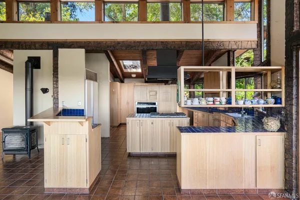 a kitchen with stainless steel appliances kitchen island granite countertop a refrigerator and a stove top oven