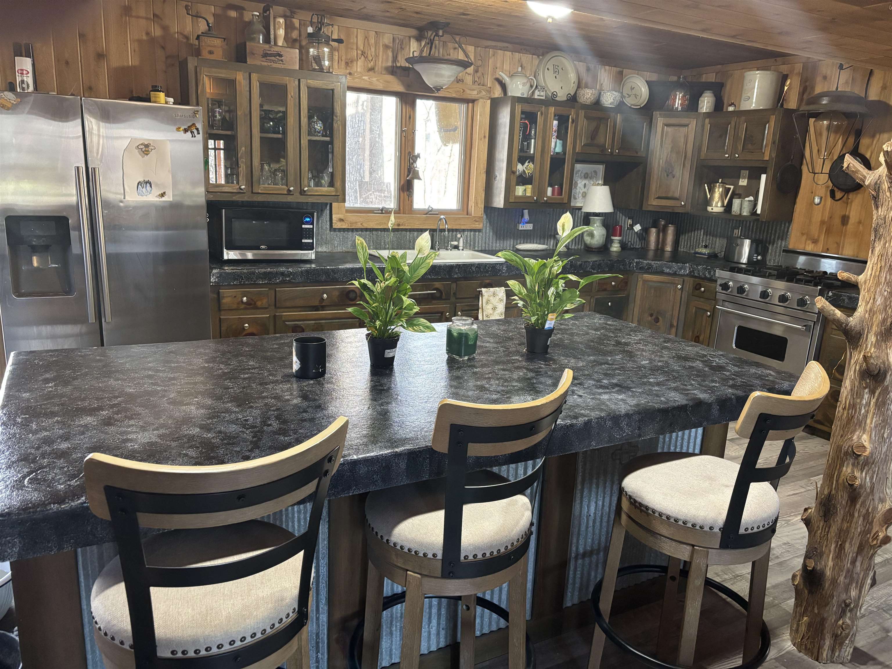 7462 Campground Road Drummonds, TN 38023 - Photo 21 of 31 Kitchen featuring wood-paneled walls and ceiling, stainless steel appliances, wood cabinetry, and a large center island with seating