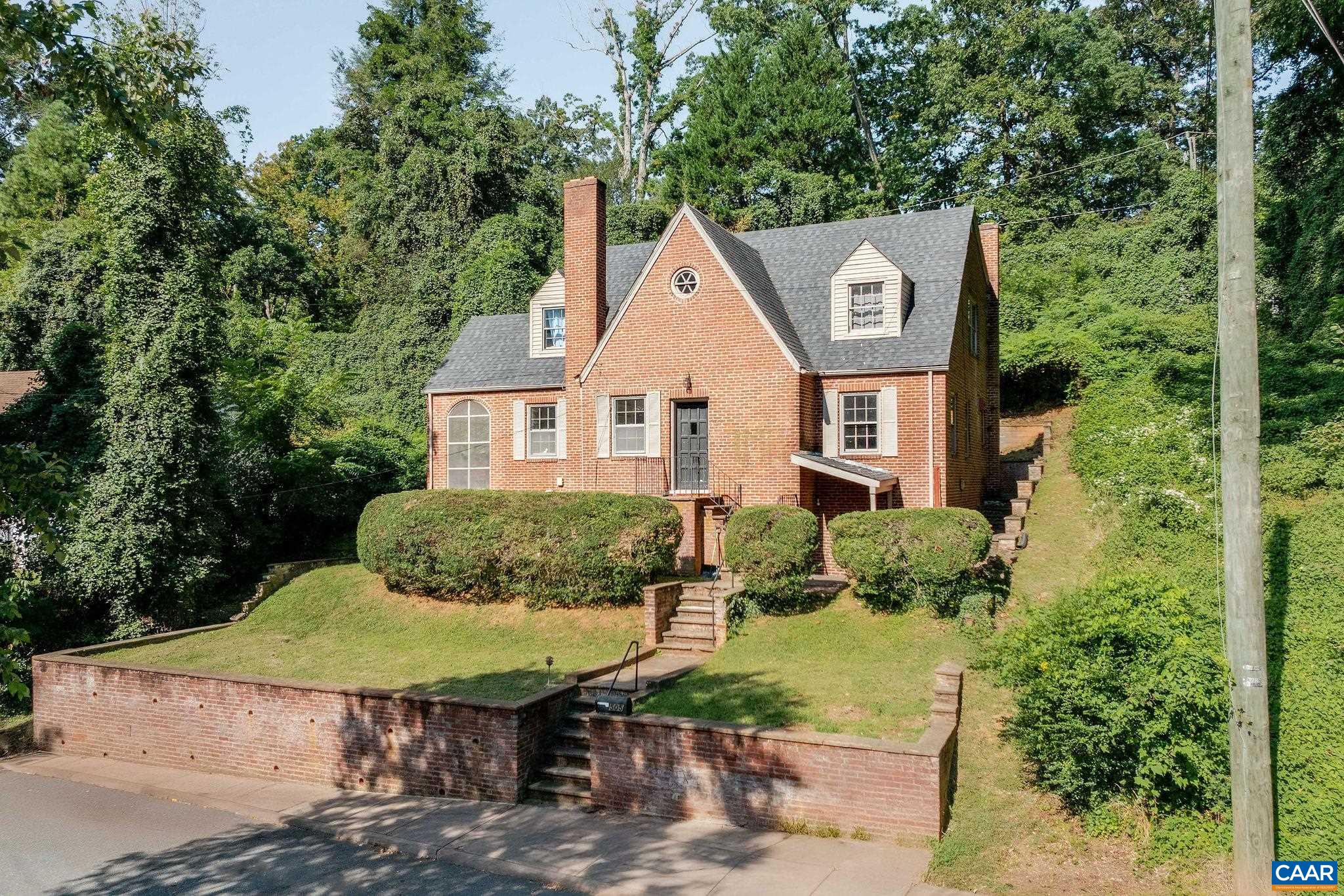 505 Valley Road Charlottesville, VA 22903 - Photo 2 of 29 a view of a brick house with a yard plants and large tree