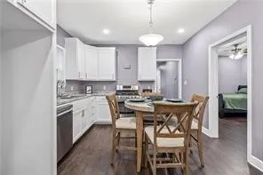 a kitchen with stainless steel appliances kitchen island granite countertop a dining table chairs and white cabinets