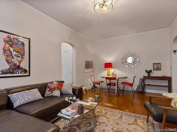 a living room with furniture and a dining table with wooden floor