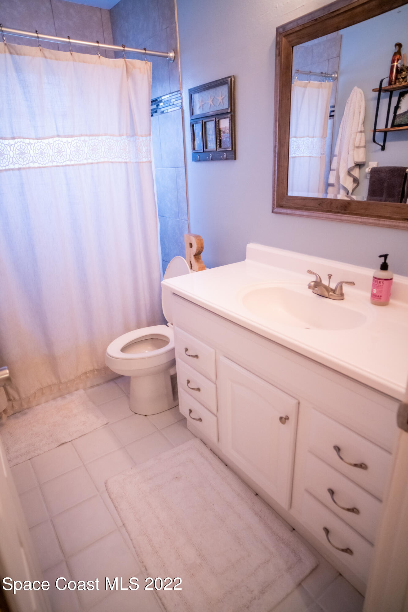 235 Capron Road Cocoa, FL 32927 - Photo 12 of 19 a bathroom with a sink a toilet and shower curtain