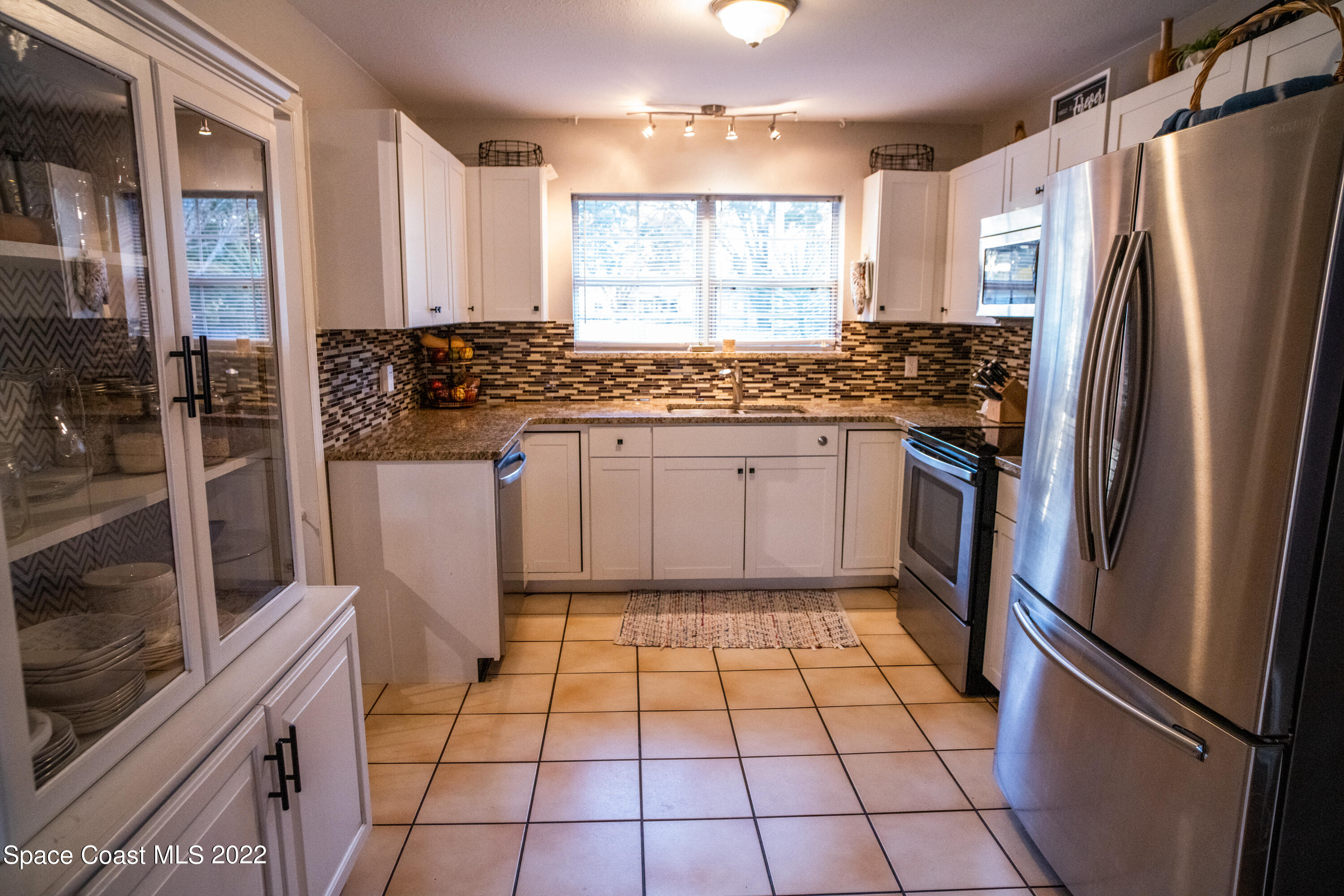 235 Capron Road Cocoa, FL 32927 - Photo 7 of 19 a kitchen with stainless steel appliances granite countertop a refrigerator and a stove top oven