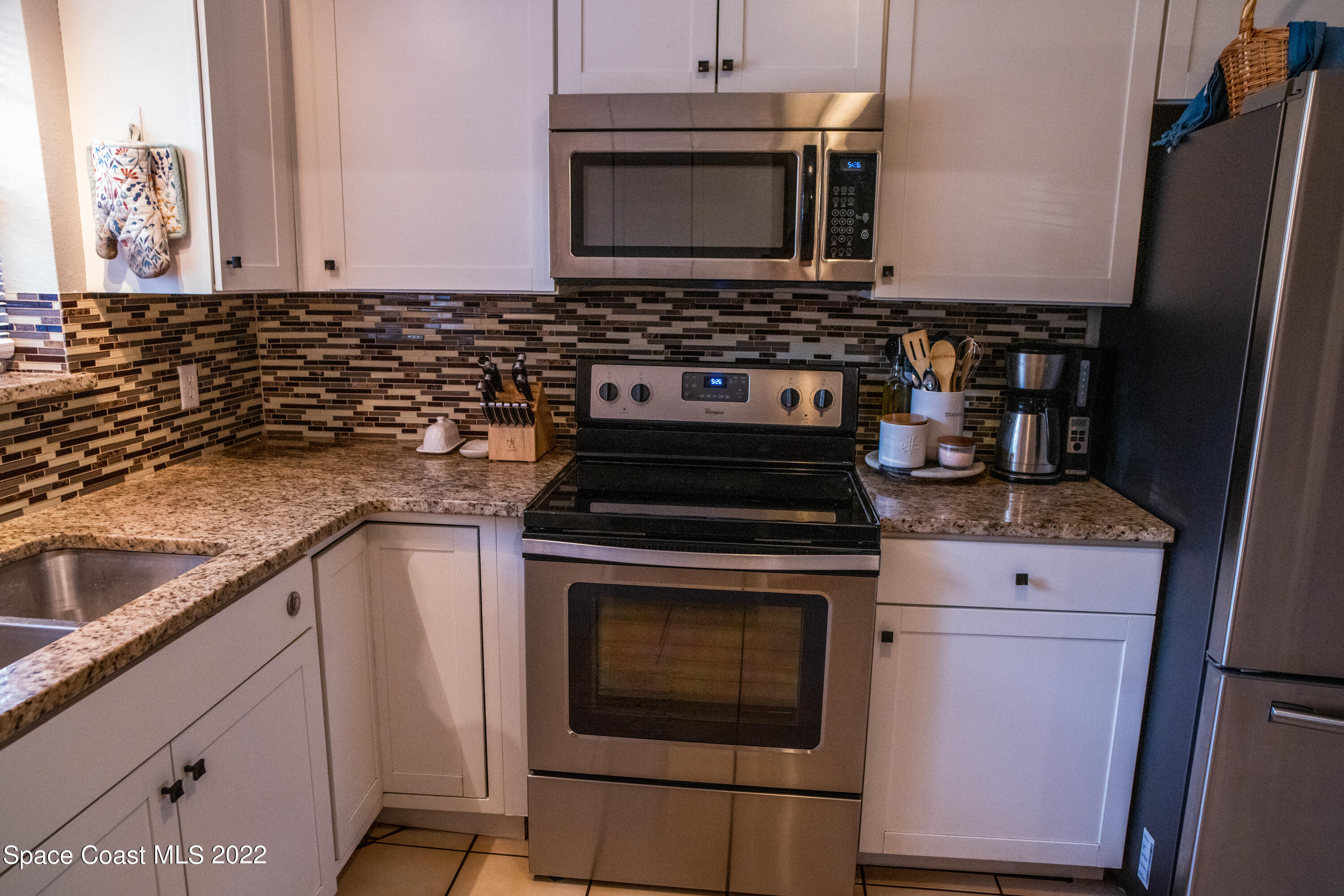 235 Capron Road Cocoa, FL 32927 - Photo 8 of 19 a kitchen with granite countertop a stove top oven microwave and cabinets