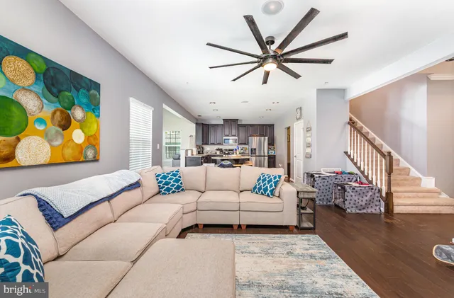 a kitchen with stainless steel appliances a dining table chairs refrigerator and cabinets