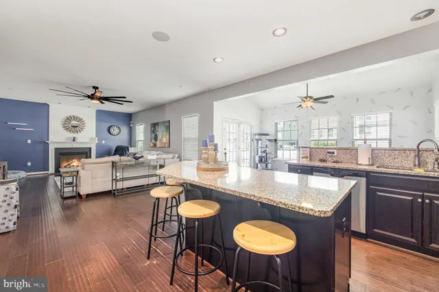 a kitchen with granite countertop a counter top space a sink stainless steel appliances and cabinets