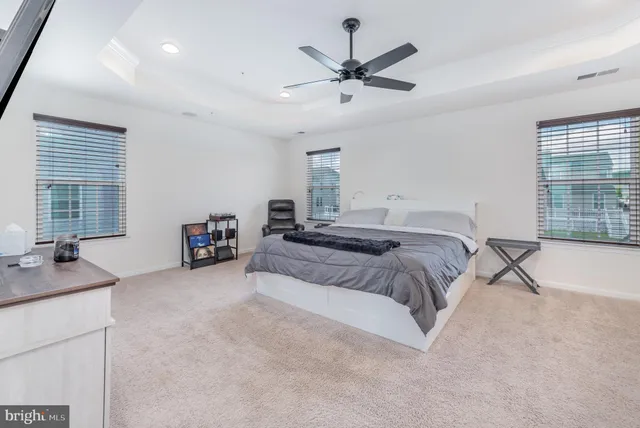 a spacious bedroom with a bed a couch and a window