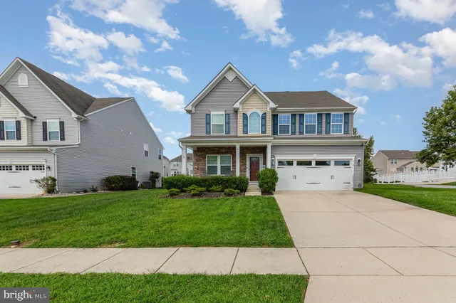 a front view of a house with a garden and yard