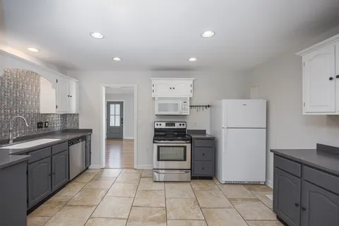 an empty room with kitchen and sink