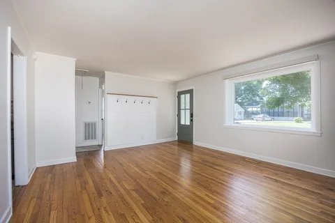wooden floor in an empty room with a window