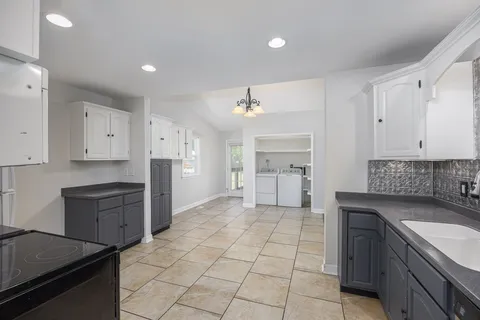 a kitchen with granite countertop cabinets appliances and a sink