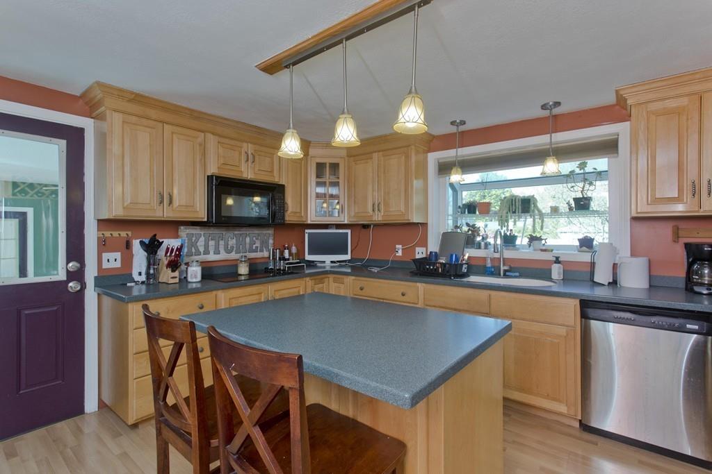38 Pine Acre Road Springfield, MA 01129 - Photo 12 of 40 a kitchen with stainless steel appliances a table chairs sink refrigerator and cabinets