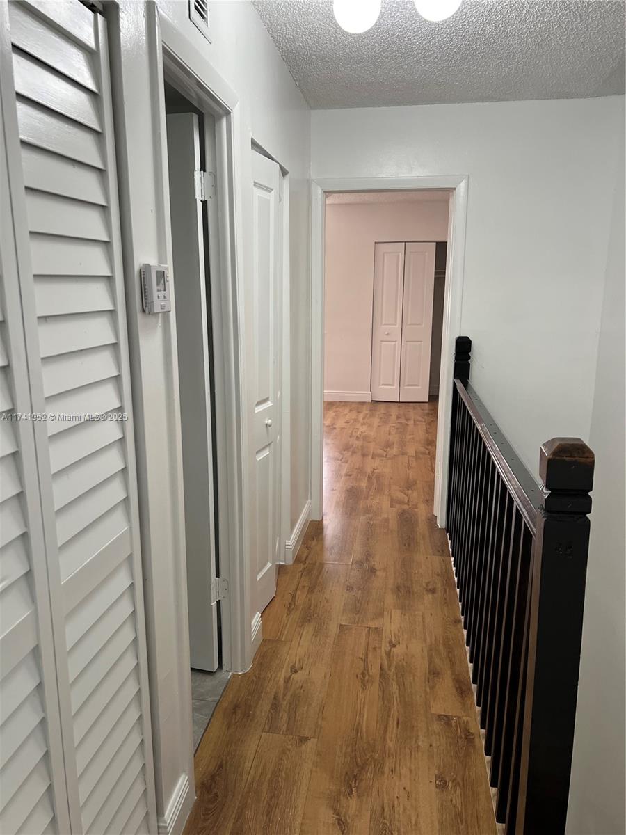 4372 West 11th Lane, Unit 30 Hialeah, FL 33012 - Photo 16 of 23 a view of a hallway with wooden floor and staircase