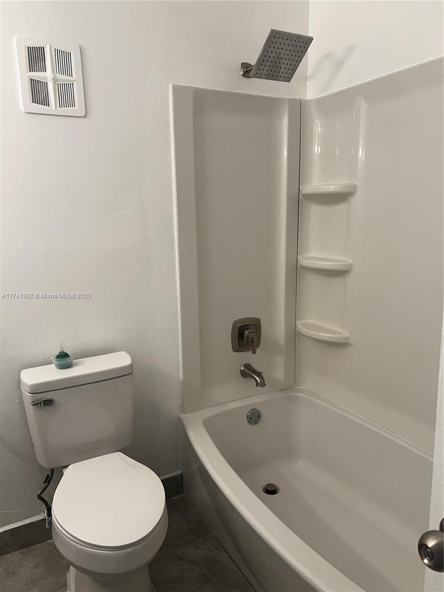 4372 West 11th Lane, Unit 30 Hialeah, FL 33012 - Photo 19 of 23 a white toilet sitting next to a bathroom sink and tub