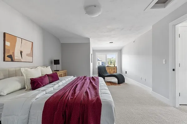 a bedroom with a bed and a painting on the wall