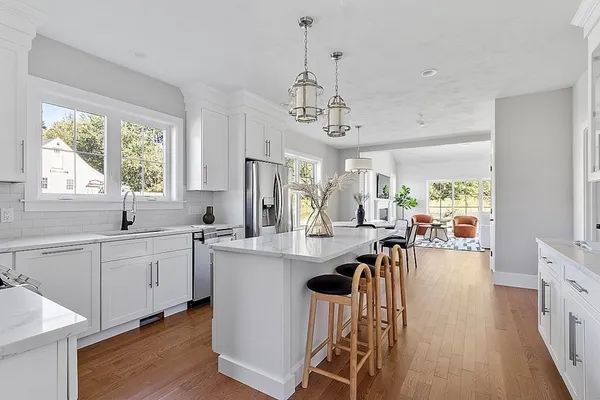 a view of a dining room and livingroom with furniture wooden floor a chandelier