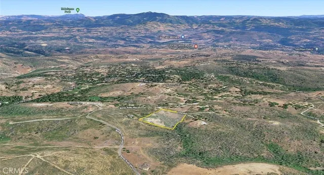 a view of a dry yard with mountains in the background