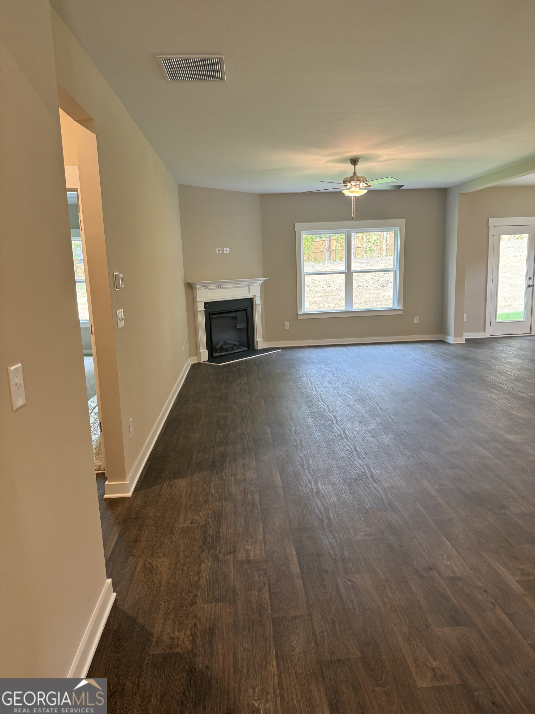 258 Westminster Court Winder, GA 30680 - Photo 2 of 16 an empty room with wooden floor and windows