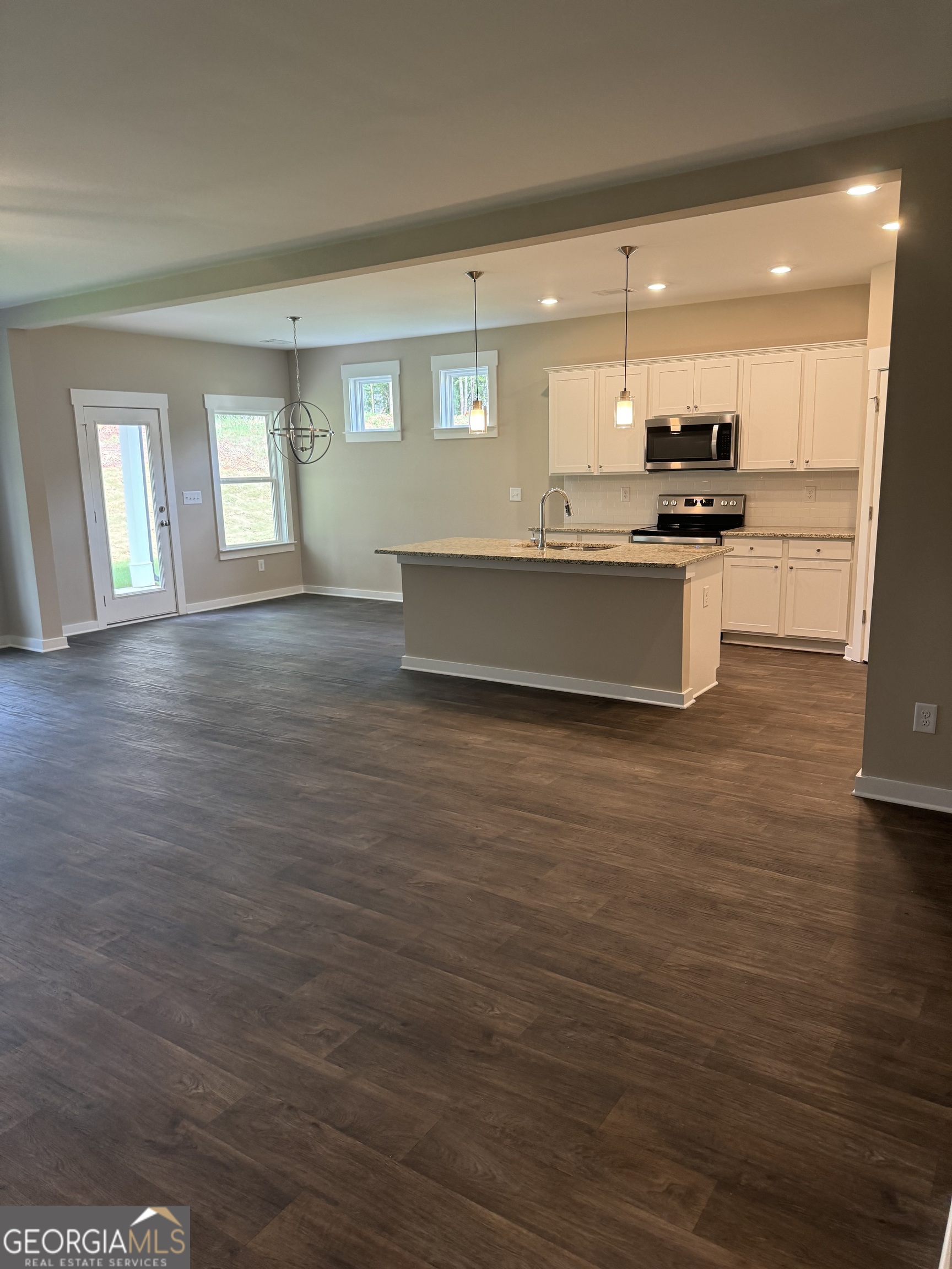 258 Westminster Court Winder, GA 30680 - Photo 3 of 16 a large kitchen with kitchen island a stove a sink dishwasher and a oven with wooden floor